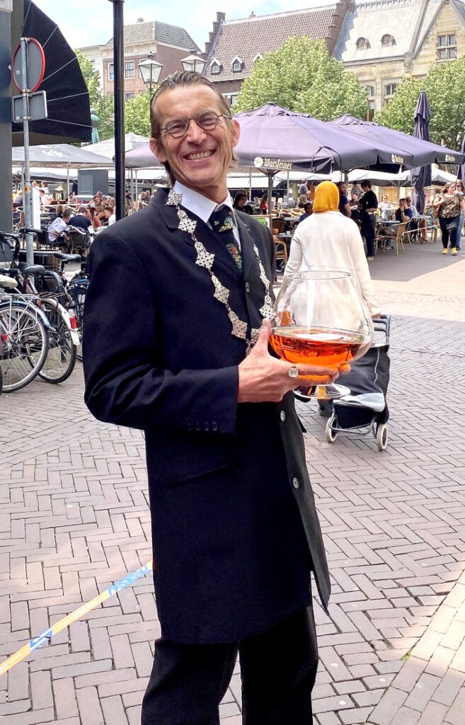 Burgemeester lachend op de markt.