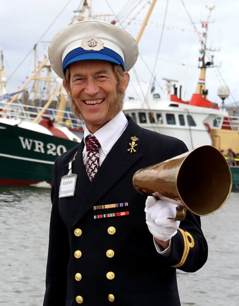 Typetje kapitein Droogsloot in de haven tijdens een havenfeest.