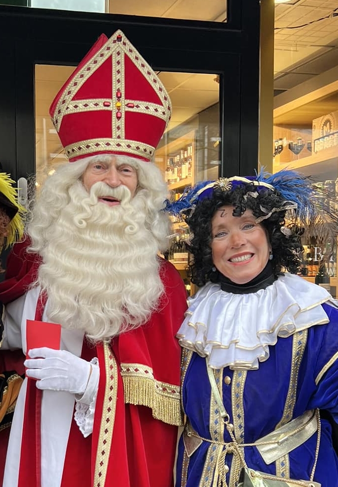 Sinterklaas en piet in een winkelstraat.