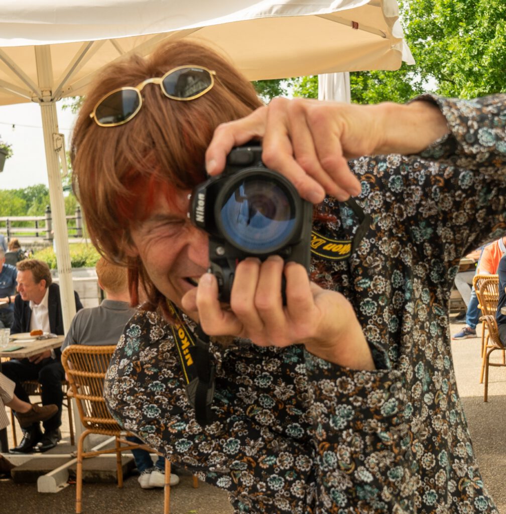 Typetje fotograaf in actie met camera.