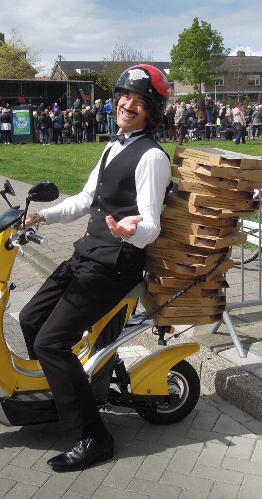 Typetje pizzakoerier lacht op zijn scootertje