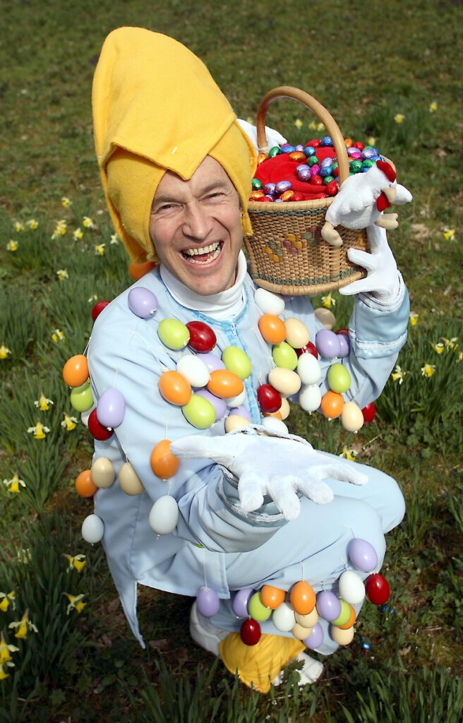 Typetje Eiermannetje kijkt lachend in de camera.