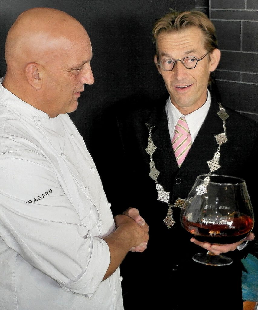 Typetje burgemeester samen met chef-kok Herman den Blijker tijdens een culinair evenement.