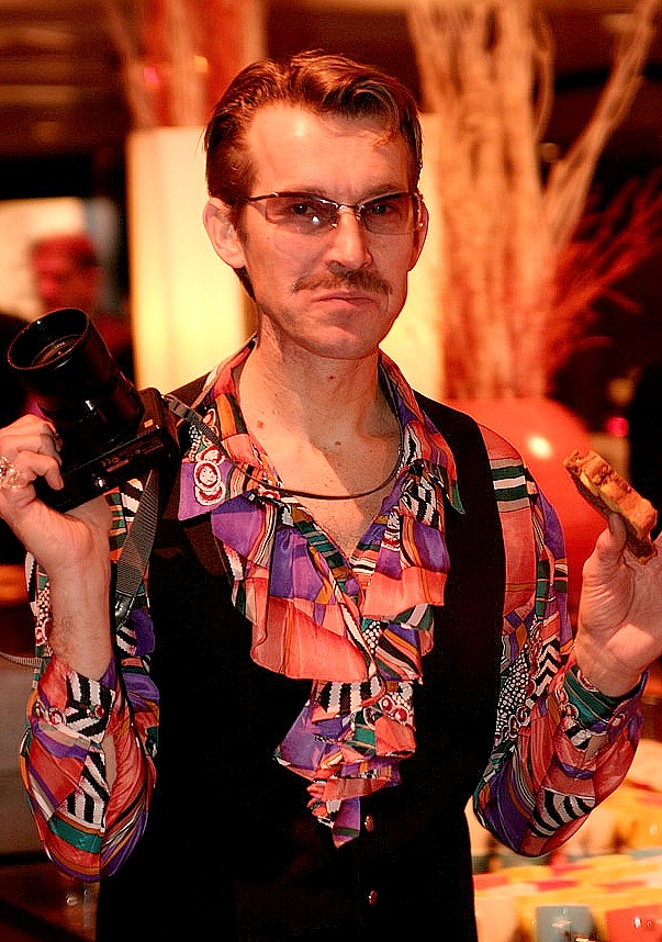 Foute fotograaf met camera in de aanslag. Komisch typetje van Free Fantasy op een bedrijfsevenement.